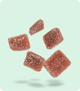 Five sugar-coated cannabis gummies floating against a soft mint-green background, representing marijuana edibles.