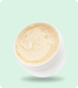 Open white jar of creamy cannabis topical product displayed on a soft mint-green background, representing marijuana topicals.