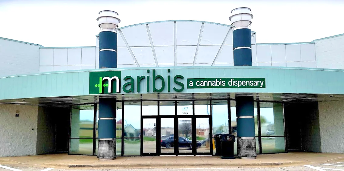 Exterior of Maribis of Springfield cannabis dispensary at 2451 Denver Drive in Springfield, Illinois, featuring the curved façade with teal accents, large glass entrance, and prominent Maribis “a cannabis dispensary” signage.